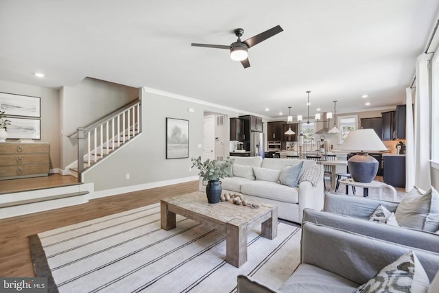  - living room with stairs, ceiling fan, light wood-style floors, recessed lighting, and baseboards