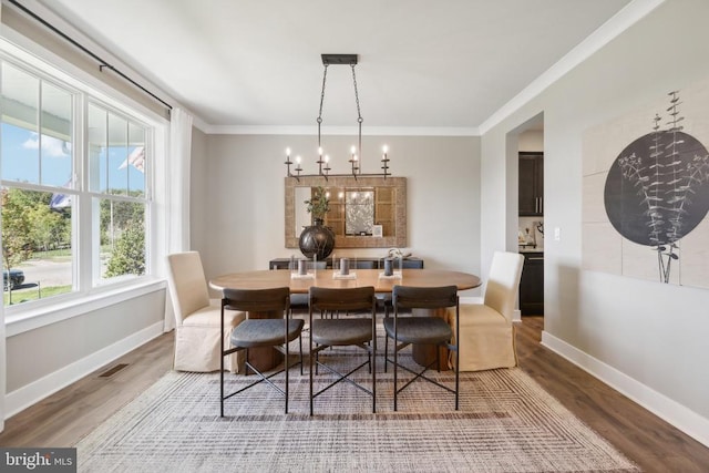  - dining room featuring baseboards, ornamental molding, wood finished floors, and a chandelier