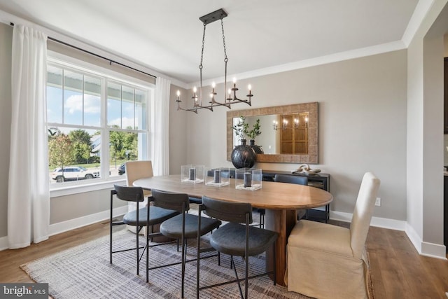  - dining area featuring baseboards, a chandelier, wood finished floors, and ornamental molding