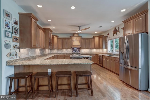 76 Retriever Ct, Bumpass, VA 23024 - kitchen featuring appliances with stainless steel finishes, a peninsula, light stone countertops, ceiling fan, and a kitchen bar