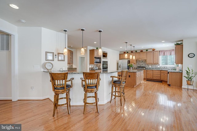 11512 Balmartin Ct, Spotsylvania, VA 22553 - kitchen featuring stainless steel refrigerator with ice dispenser, black microwave, backsplash, light wood finished floors, and recessed lighting