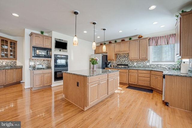 11512 Balmartin Ct, Spotsylvania, VA 22553 - kitchen with black appliances, decorative backsplash, a center island, light wood finished floors, and hanging light fixtures