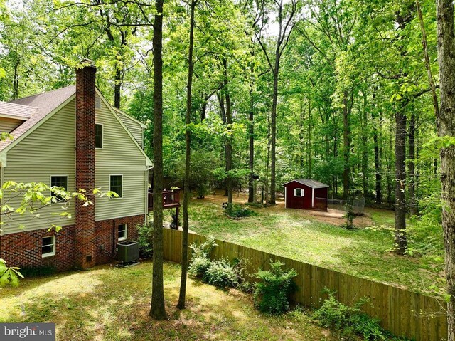 9128 Woodbrook Ln, Culpeper, VA 22701 - view of yard with a storage shed, central AC unit, an outbuilding, and a forest view