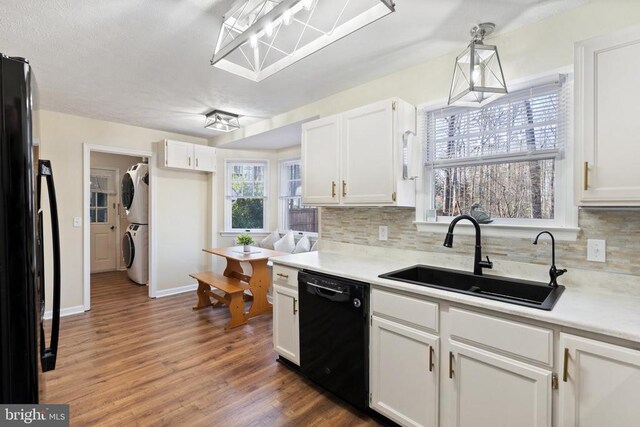 9128 Woodbrook Ln, Culpeper, VA 22701 - kitchen with black appliances, estacked washer and dryer, a sink, and backsplash