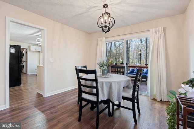 9128 Woodbrook Ln, Culpeper, VA 22701 - dining area featuring stacked washing machine and dryer, dark wood-type flooring, baseboards, and a chandelier