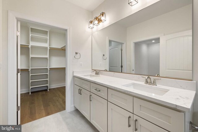 57 Madison St, Warrenton, VA 20186 - full bathroom with double vanity, a walk in closet, baseboards, and wood finished floors