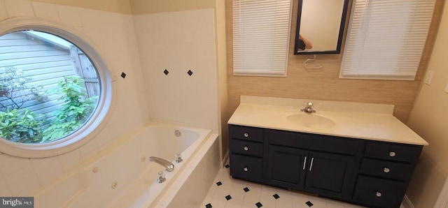 full bath featuring a tub with jets, vanity, and tile patterned flooring