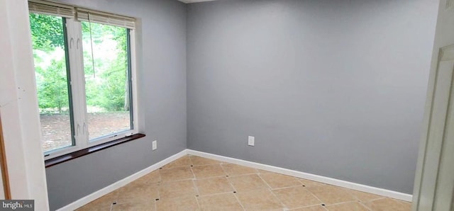 unfurnished room featuring light tile patterned floors and baseboards
