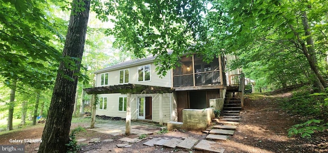 rear view of property with a pergola, a sunroom, stairs, and a patio