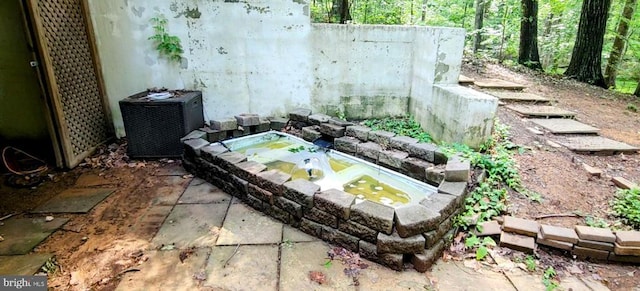 exterior space with cooling unit and a hot tub