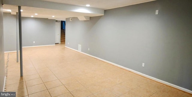finished basement featuring recessed lighting, baseboards, light tile patterned flooring, and stairway