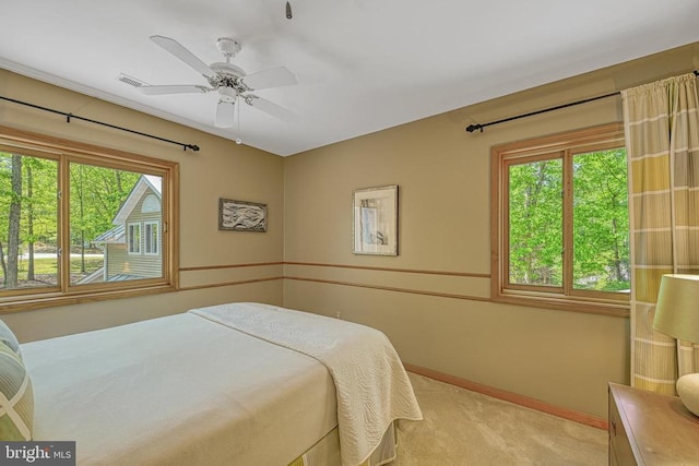 bedroom featuring light colored carpet, baseboards, and ceiling fan