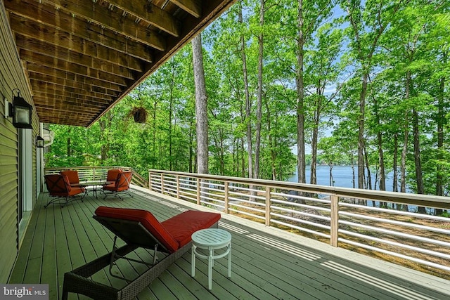 wooden terrace featuring a water view and view of wooded area