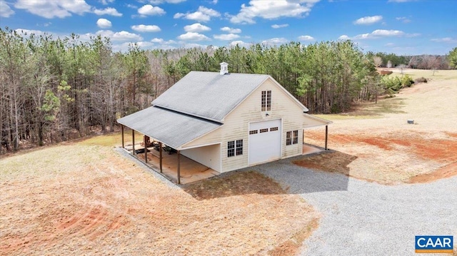 1660 Lees Mill Ln, Goode, VA 24556 - view of property exterior featuring a detached garage, a view of trees, and driveway