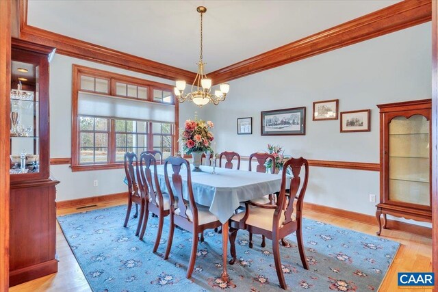 1660 Lees Mill Ln, Goode, VA 24556 - dining room featuring crown molding, wood finished floors, a chandelier, and baseboards