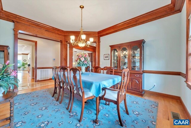 1660 Lees Mill Ln, Goode, VA 24556 - dining room with ornamental molding, a chandelier, decorative columns, wood finished floors, and baseboards