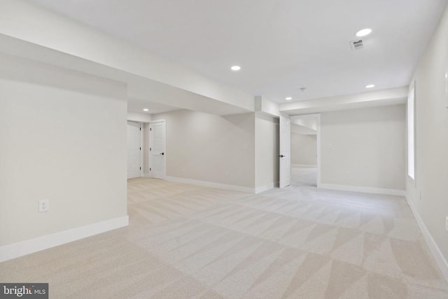 finished basement featuring light carpet, visible vents, recessed lighting, and baseboards