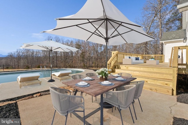 view of patio / terrace featuring a fenced in pool, fence, outdoor dining area, outdoor lounge area, and a deck