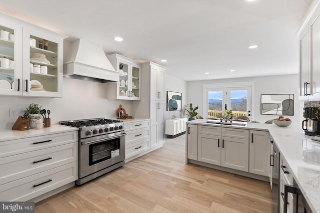 kitchen featuring premium range hood, recessed lighting, light wood-style floors, stainless steel stove, and white cabinets