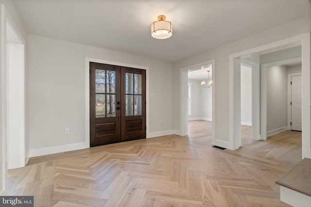 foyer entrance featuring french doors and baseboards