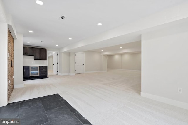 unfurnished living room featuring recessed lighting, visible vents, wine cooler, and light colored carpet