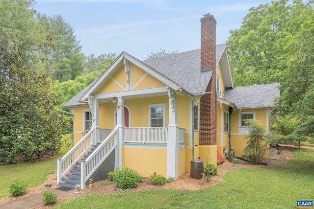 2523 Stony Point Rd, Charlottesville, VA 22911 - view of front of house with stucco siding, covered porch, roof with shingles, a chimney, and a front lawn
