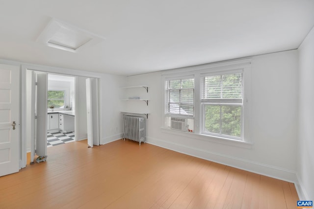 2523 Stony Point Rd, Charlottesville, VA 22911 - unfurnished living room featuring radiator heating unit, light wood-type flooring, attic access, and cooling unit