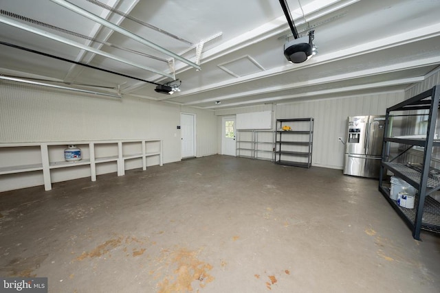  - garage featuring stainless steel refrigerator with ice dispenser and a garage door opener