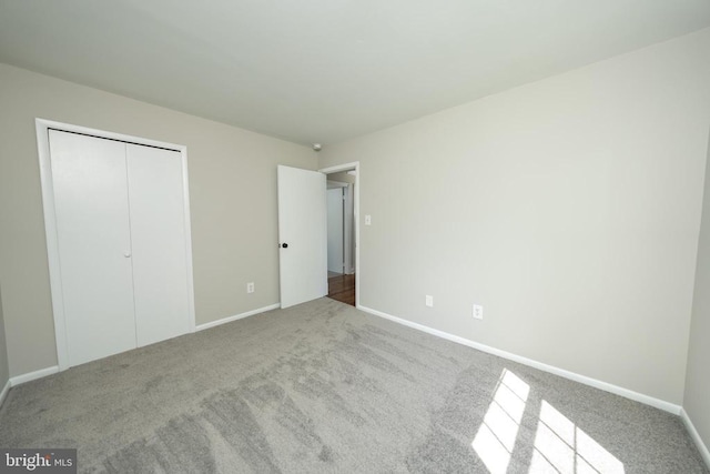  - unfurnished bedroom with carpet floors, a closet, and baseboards