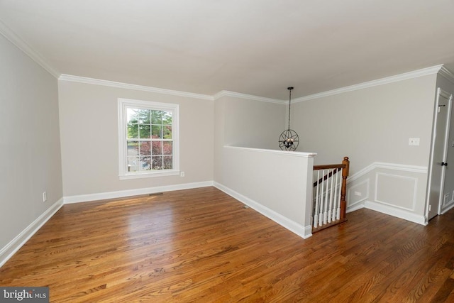  - unfurnished room featuring baseboards, ornamental molding, and wood finished floors