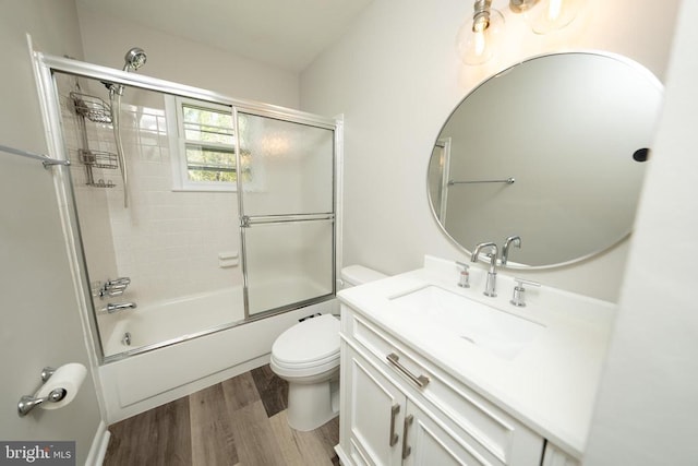  - full bathroom with enclosed tub / shower combo, vanity, toilet, and wood finished floors