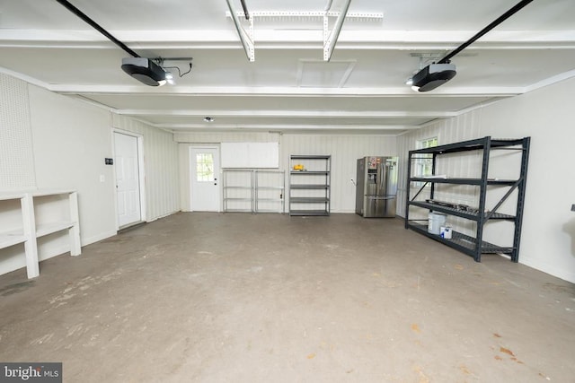  - garage featuring a garage door opener and stainless steel refrigerator with ice dispenser