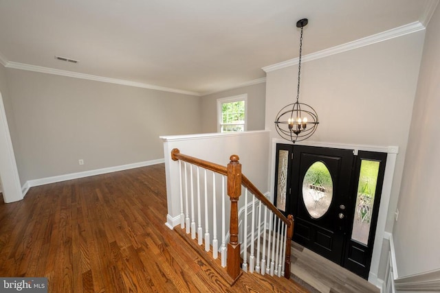  - foyer featuring wood finished floors, crown molding, visible vents, baseboards, and a chandelier