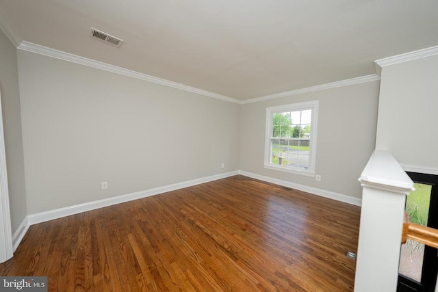  - empty room featuring crown molding, wood finished floors, visible vents, and baseboards