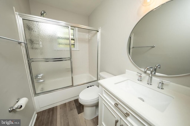  - full bath with vanity, toilet, combined bath / shower with glass door, and wood finished floors