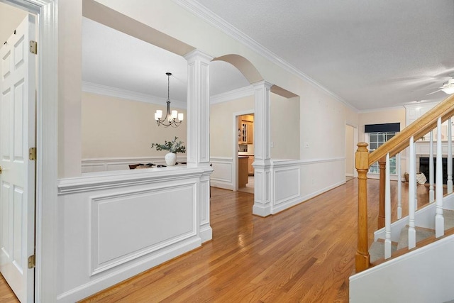101 Jasper Ln, Waynesboro, VA 22980 - hallway with decorative columns, crown molding, light wood-type flooring, a wainscoted wall, and stairway