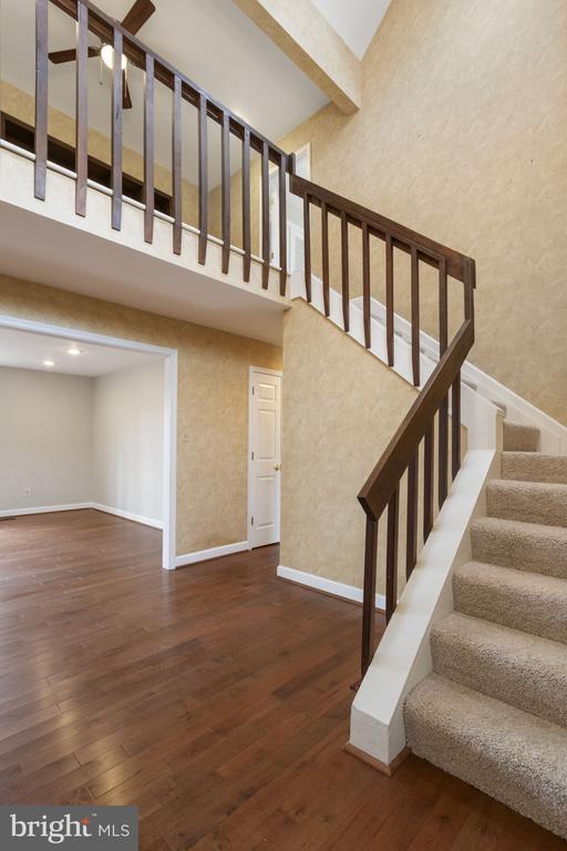 9 Twin Springs Dr, Fredericksburg, VA 22407 - staircase with wood finished floors, baseboards, and a towering ceiling