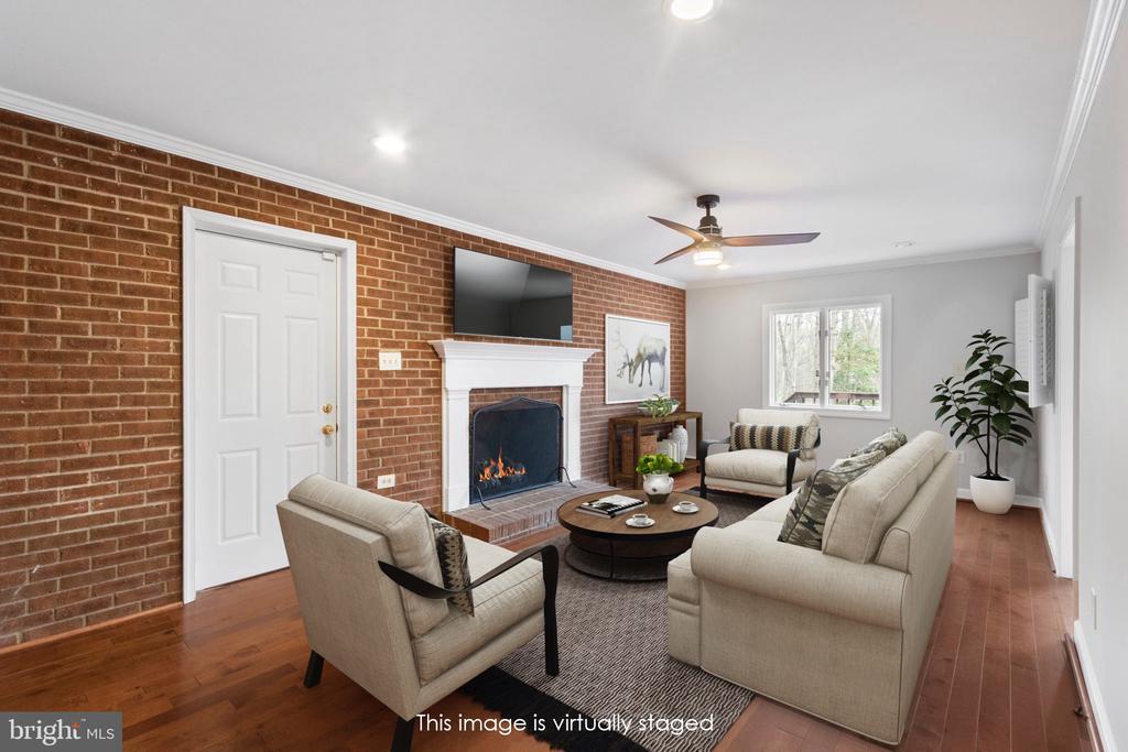 9 Twin Springs Dr, Fredericksburg, VA 22407 - living room featuring brick wall, hardwood / wood-style floors, ceiling fan, ornamental molding, and a fireplace