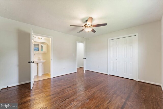  - unfurnished bedroom with dark wood-style flooring, a closet, and a ceiling fan