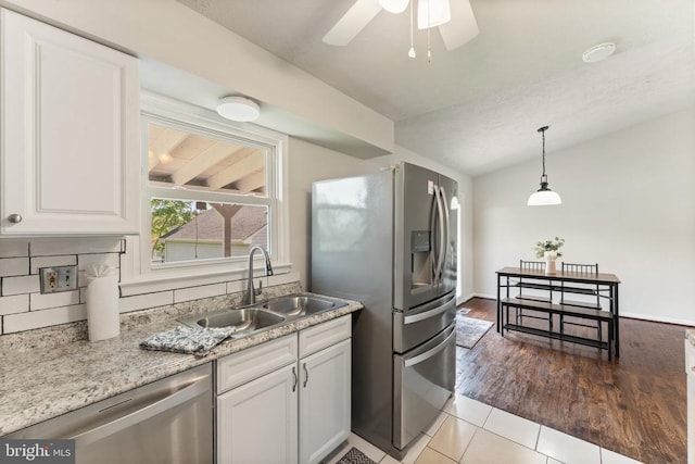  - kitchen with appliances with stainless steel finishes, white cabinets, ceiling fan, hanging light fixtures, and lofted ceiling