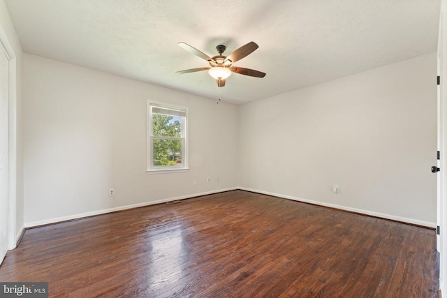  - empty room featuring ceiling fan and dark wood-style flooring