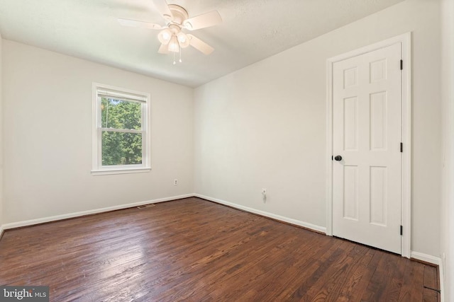  - empty room featuring dark wood finished floors and ceiling fan