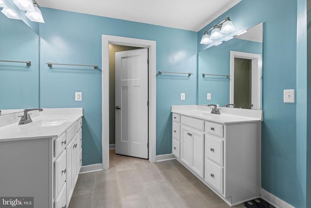  - bathroom featuring two vanities and baseboards