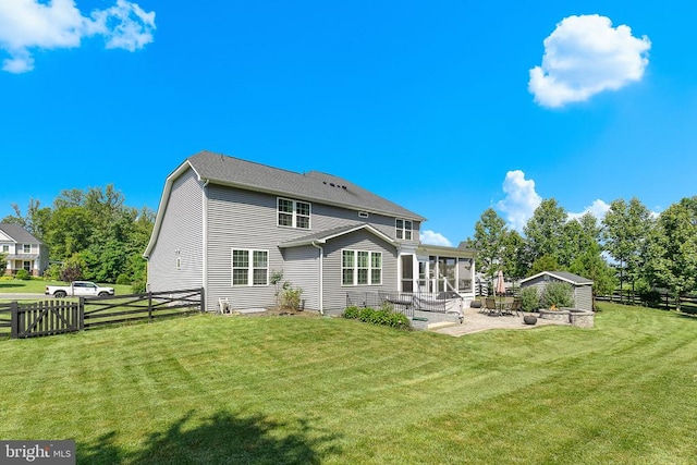 - rear view of property featuring a sunroom, a patio area, and an outdoor structure