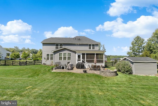  - back of property with a fire pit, a sunroom, a patio, a fenced backyard, and a storage shed