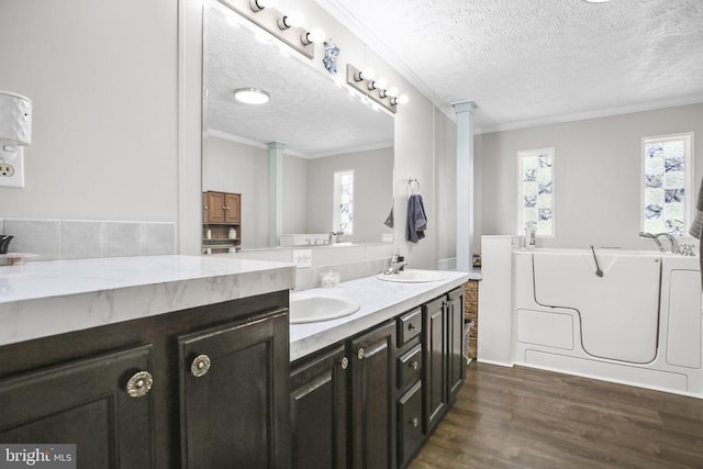 4253 Rolling Hills Dr, Culpeper, VA 22701 - bathroom featuring a textured ceiling, wood finished floors, double vanity, healthy amount of natural light, and a bathtub