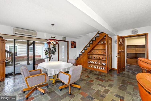 41 Carr Cir, Mineral, VA 23117 - dining room with a wall mounted air conditioner, stairs, stone tile floors, a textured ceiling, and baseboards