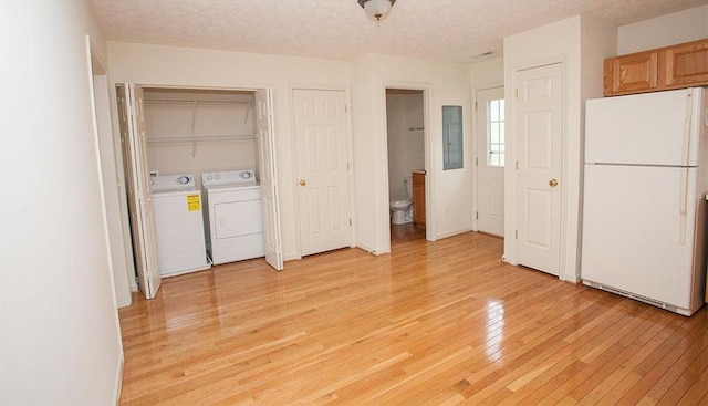 196 Emerson Ln, Harrisonburg, VA 22801 - unfurnished bedroom featuring freestanding refrigerator, washer and clothes dryer, light wood-style floors, multiple closets, and a textured ceiling
