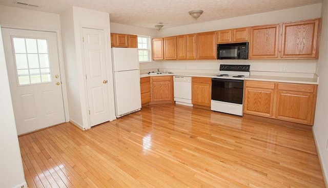 196 Emerson Ln, Harrisonburg, VA 22801 - kitchen featuring white appliances, a sink, light wood-type flooring, light countertops, and baseboards