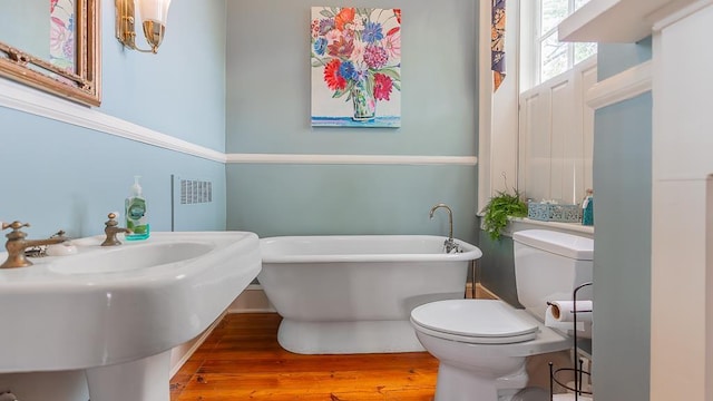 111 Main St S, Bridgewater, VA 22812 - bathroom with a freestanding bath, wood finished floors, toilet, radiator heating unit, and a sink